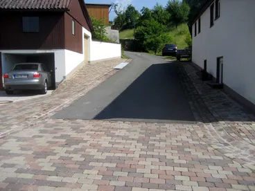 Neu gepflasterte Dorfstraße mit Asphaltfahrbahn und Pflasterflächen