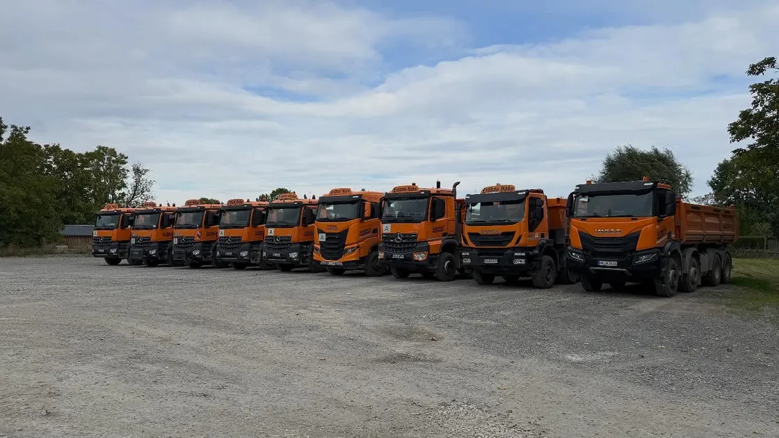 Neun Kipper-LKW der Erdbau-Hake-Flotte aufgereiht auf dem Betriebshof