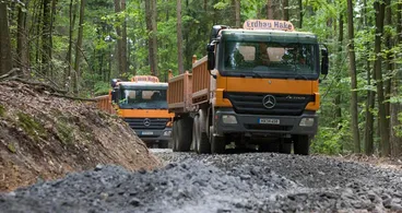 Zwei Kipper-LKW von Erdbau Hake auf einem frisch geschotterten Waldweg